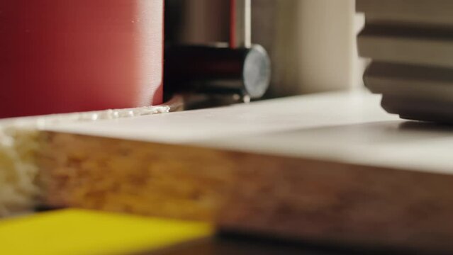 Close-up of carpenter cutting a wooden plank, circular saw on wooden factory, furniture production, handmade craft table.