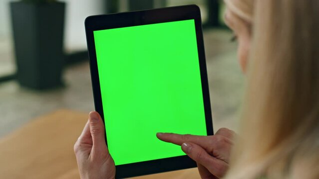 Lady finger swiping greenscreen tablet at office. Anonymous woman surfing web