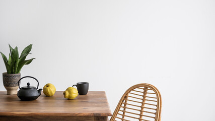 dining table with teapot, cup and fruit in kitchen