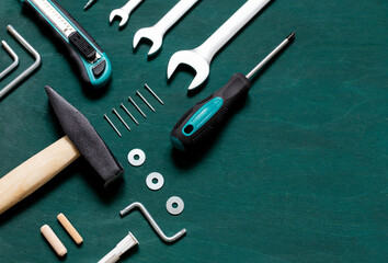 Set of professional tools for renovation or home repairs on the green wooden background. Copy space