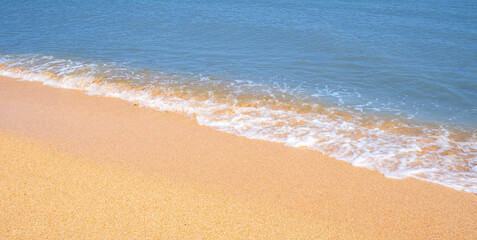 The coast of the Sea of Azov. Sea waves roll on the sandy shore. Seashell sandy beach.