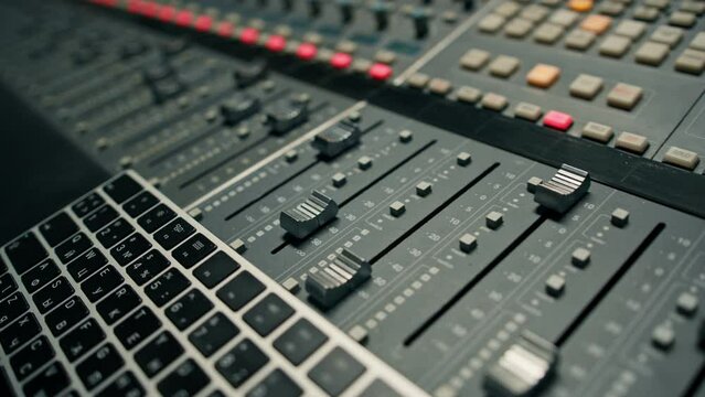 Close-up of mixer console hand adjusting faders A sound engineer works in the studio Professional recording studio 
