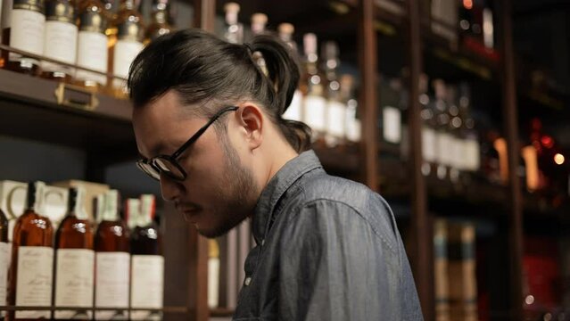 Night club concept of 4k Resolution. The bartender is checking the merchandise in the store. A group of specialized clubs that sell alcoholic beverages.