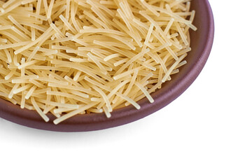 Pasta noodles in a clay ceramic bowl close-up isolated on a white background