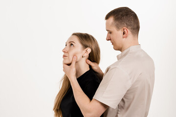 Obraz na płótnie Canvas Orthopedist examining female neck and head. Manual correction of the ridge and cervical region. Rehabilitation therapy on white background. Manual therapy at physiotherapist or chiropractor.
