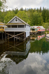 Fototapeta na wymiar Telegraph Cove Historic Boardwalk Buildings on Pilings vertical. The Telegraph Cove marina and accommodations built on pilings surrounding this historic location.