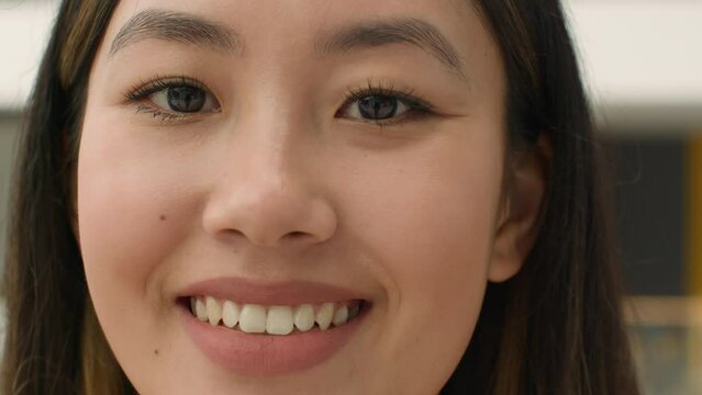 Close up face happy Asian woman smiling chinese korean japanese girl looking at camera head shot joyful lady with natural beauty make-up toothy smile client of cosmetology dental service healthcare