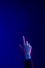 Fototapeta premium Asian man pointing finger in studio with blue light with copy space