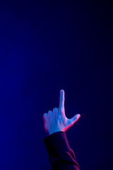 Asian man pointing finger in studio with blue light with copy space