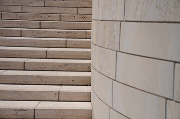 Details of a staircase made of light colored blocks, next to a wall of the same material