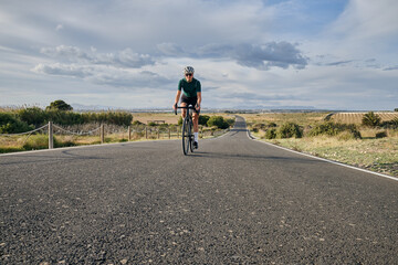 fit young female cyclist riding on the road on a gravel bike at sunset.Empty city road.
Sport...