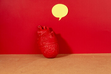 Still life concept communication with heart and yellow bubble on red background