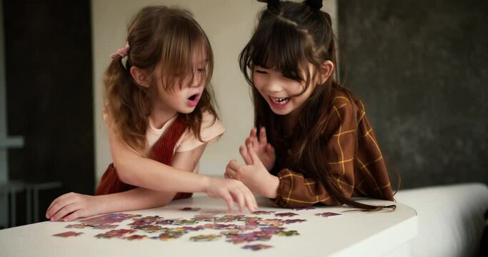 Two diverse children playing puzzles at home