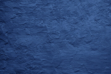 Toned painted old concrete wall with plaster. Dark blue vintage texture background with space for...