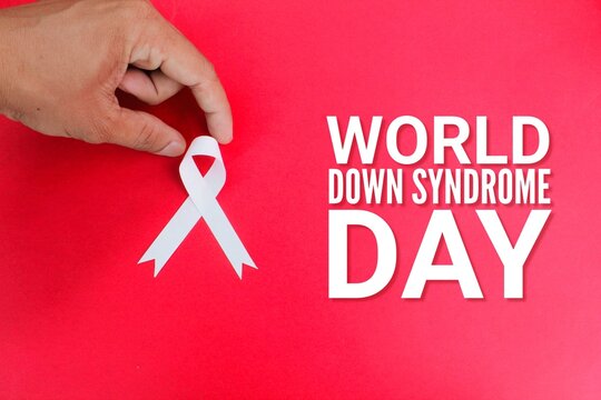 hand stretching the ribbon with the words World down syndrome day. World down syndrome day and learning difficulties awareness concept - Powered by Adobe