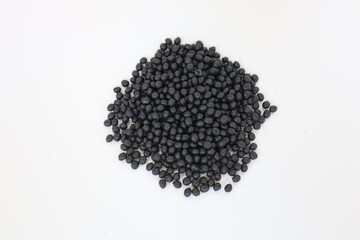 Plastic pellets for production, plastic polymer dye granules color black  on white background.