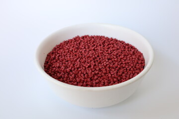 Red plastic pellets, rubber granules on a white background

