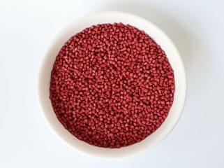 Red plastic pellets, rubber granules on a white background

