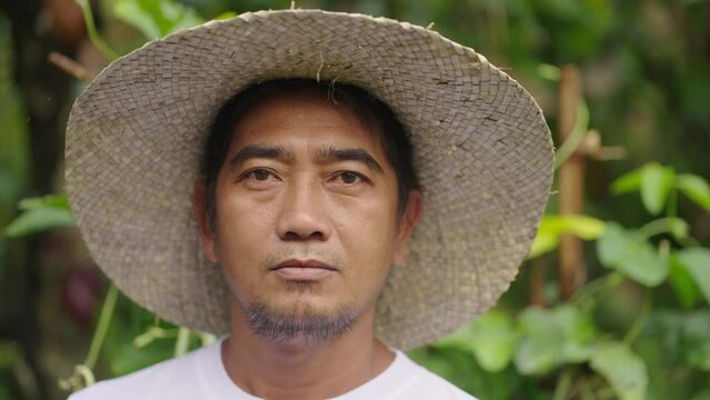 serious asian farmer on rural farm in asia, poverty and hardship, looking