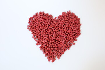 Fototapeta na wymiar Red plastic pellets, rubber granules on a white background