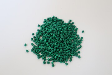 Primary color mix. Green plastic pellets, rubber granules on a white background