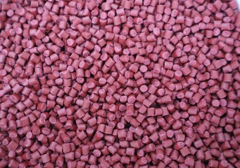 Red plastic pellets, rubber granules on a white background

