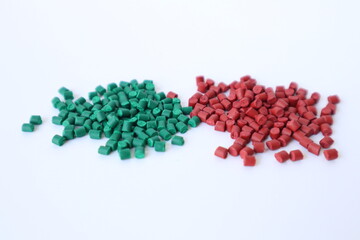 Primary color mix. Green plastic pellets, rubber granules on a white background