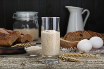 Glass with fresh sourdough on wooden table