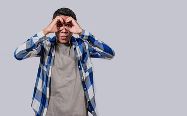 Curious man making binoculars gesture, Guy on isolated background making binoculars gesture, Man making binoculars gesture, man using his fists as binoculars