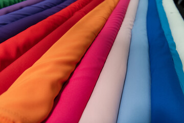 Collection of fashionable fabrics. Samples of different natural fabrics for sewing a fashion collection of clothes. Large selection of fabrics in the store or tailor warehouse.