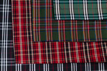 Collection of Scottish fashionable fabrics . Samples of different natural fabrics for sewing a fashion collection of clothes. Large selection of fabrics in the store or tailor warehouse.
