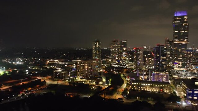 Downtown Austin, Texas skyline at night with drone video panning left to right.