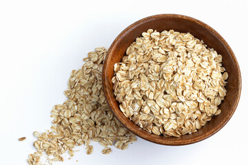 Dry rolled oatmeal in bowl isolated on white background.