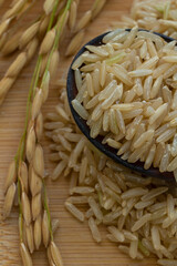 brown rice and wooden spoon on wood background