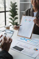 Team of business people, accounting consultants meeting to discuss graph analysis and data charts showing earnings, financial reports, revenues, taxes in the conference room.
