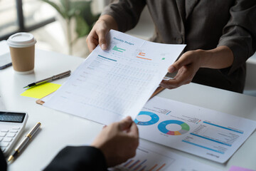 Accounting consultant, businesswoman handing in documents showing detailed information on graphs and data charts showing earnings, financial reports, income, taxes in the office.