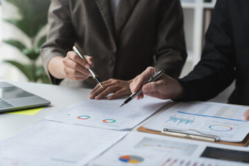 Work team meeting concept with financial plan, meeting, discussion, brainstorming and pointing to graph data sheet. Business turnover chart on office desk.