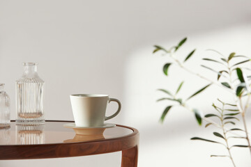 This room has a calm atmosphere with natural light. There are clay pots, glass bottles, coffee and various objects on the table.