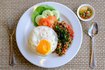 Stir Fried Basil with Pork and a fried egg on the table