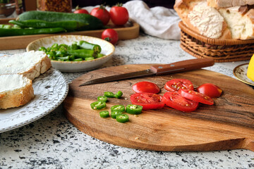 Close-up chopped cherry tomatoes and green peppers for making bruschetta with cream cheese.