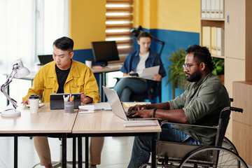 Man with disability working in office with diverse business team
