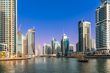 Fototapeta na wymiar Twilight at the Dubai Marina, a waterfront promenade of shops, boat marinas and skyscrapers, along the coast of Dubai, United Arab Emirates. 