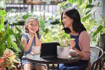 Homeschooling parents, Mother and daughter spending time together at the garden while using digital tablet for home school teaching.