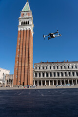 drone flying over Venice with San Marco bell tower and blue sky