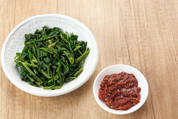 Plecing Kangkung or Brambang Asem, made from boiled spinach served with chili sauce (sambal), spicy and sour. Indonesian food
