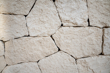 Closeup white house wall element revetted with a natural stone. White background.