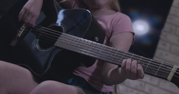 Bright Teenage Girl Learns To Play The Black Guitar