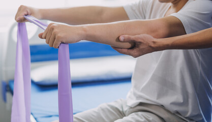Doctor or Physiotherapist working examining treating injured arm of athlete male patient, stretching and exercise, Doing the Rehabilitation therapy pain in clinic.