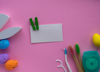 Wooden toothbrushes with Easter decorations on pink background