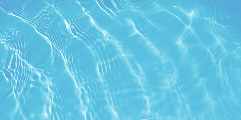 Water waves surface hits the sunlight. Close up swimming pool water background. Transparent water surface.